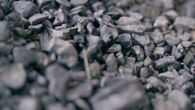 Fossil coal close-up, reserves. Smooth motion close-up over near hard coal in a warehouse. Raw materials for heating and electricity production. Unlimited use of the planet's resources