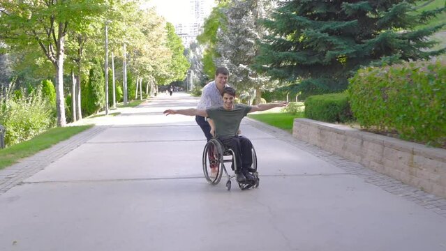 A physically disabled young man is walking with his friend outdoors.
Disabled young man and his friend are having fun and happy.
