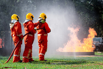Firefighters safety using twirl water fog type fire extinguisher to fighting with fire from oil and gas to control fire not to spread out Firefighter stop this accident and safety concept.