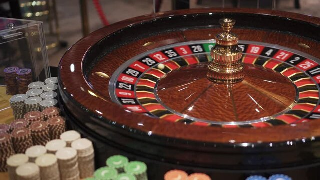 Roulette and bouncing ball, playing chips around, casino closeup view