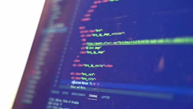 Source code for a new website is scrolled by while a computer hacker looks at how to exploit the network