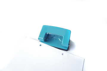 Perforator, blue hole puncher is going to punch the paper isolated on a white