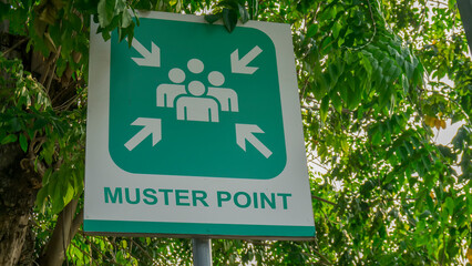 Muster Point signboard with green tree leaves background,