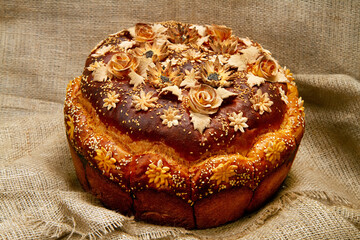 A loaf of bread with decorations on the background of burlap.