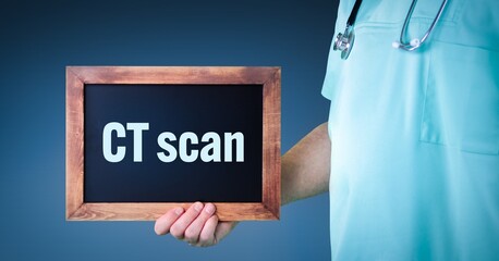 CT scan (computerised tomography). Doctor shows sign/board with wooden frame. Background blue