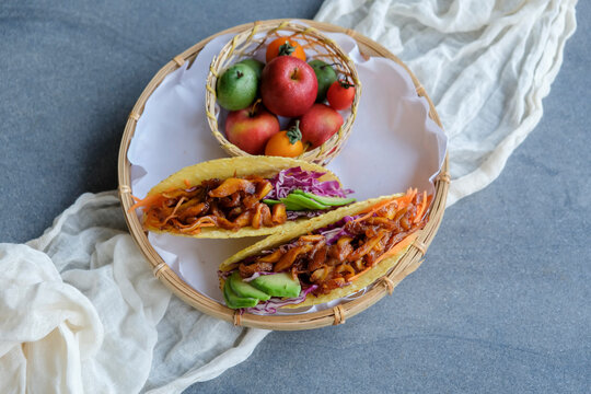 Homemade Healthy Snacks. Vegan Pulled Pork Taco Fold With Mixed Fruits Basket. Good For Between Meals Snack, Made From Jackfruit Flesh As Pork, Bbq Sauce, Purple Cabbage, Carrots Taco Shell