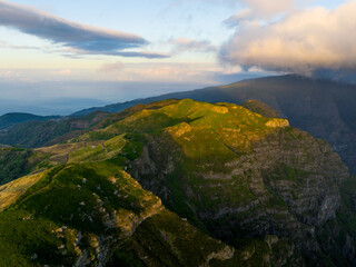 Fototapeta na wymiar Madeira Island Aerial View. Scenic View During Sunrise. Green Mountains and Cloudy Sky. Portugal. Europe.