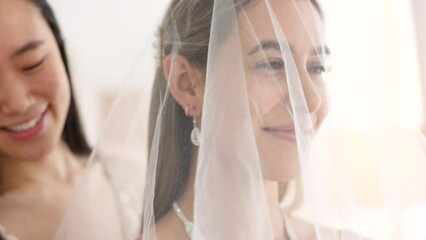 Woman helping bride with wedding veil in boutique for fashion, luxury fabric and choice design. Happy people or women in bridesmaid support fin dressing room for beauty or bridal customer service