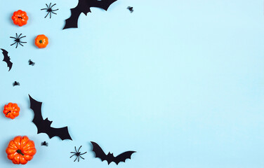 Halloween blue background with spiders, bats and pumpkins.