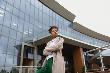 portrait of a serious young black woman on the background of a modern city building