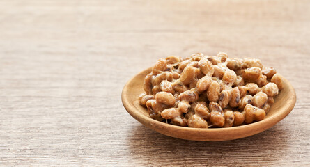 Natto or Fermented Soybean in wood plate on wooden table background. Natto or Fermented Soybean Japanese food