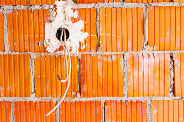 Place for electrical jack that will be installed into brick wall of unfinished residential edifice