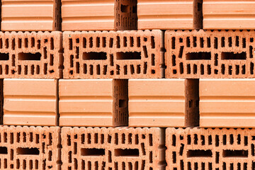 Red ceramic bricks at the construction site. Keramoblock. Hollow brick. Construction of a red brick building. Close-up. Material for the construction of walls and partitions.