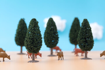 Miniature scene of cattle farm under blue sky and white clouds
