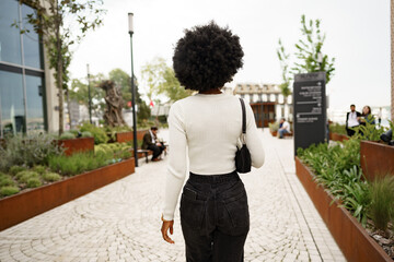 Back view of african woman walking in city