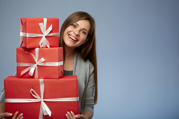 Happy woman holding stack of presents. Isolated female portrait. Girl celebrate Christmas or some thing more.