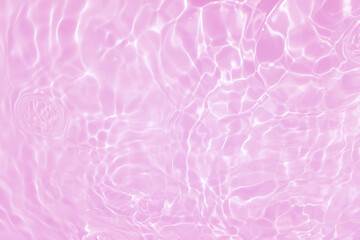 Defocus blurred transparent pink colored clear calm water surface texture with splash, bubble. Shining pink water ripple background. Surface of water in swimming pool. Tropical pink water color flow.