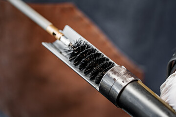 Close up of a gunsmith cleaning firearm barrel with ramrod brush