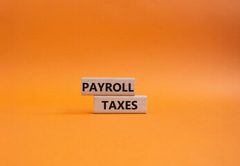 Payroll taxes symbol. Concept word Payroll taxes on wooden blocks. Beautiful orange background. Business and Payroll taxes concept. Copy space