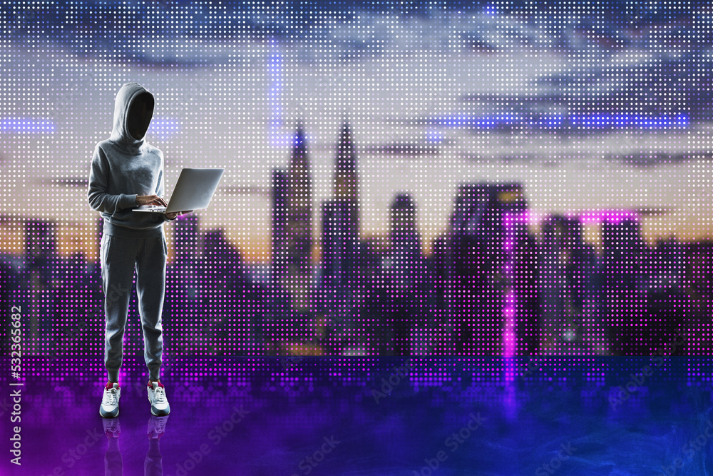 Aufkleber hacker in hoodie holding laptop and standing on abstract glowing pixel wall blurry city background. 