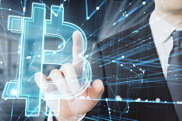 Close up of businessman hand pointing at abstract glowing holographic bitcoin icon on blurry office interior background. Cryptocurrency, online banking and money concept. Double exposure.