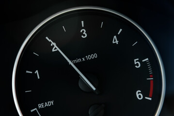 Tachometer or revolution counter, RPM gauge with needle on car dashboard.