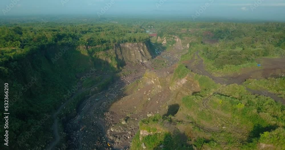 Poster aerial view of big valley overgrown by trees on the slope of volcano as a path for lava flows when a