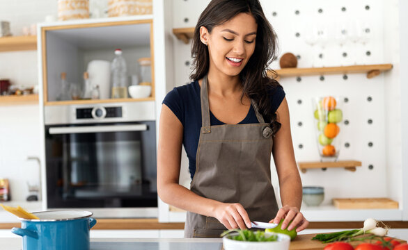 Woman Making Salad In Kitchen Smiling And Laughing Happy And Cheerful.