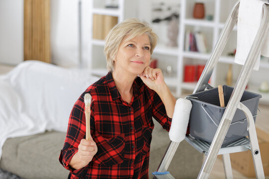 senior woman as a painter in front of white background