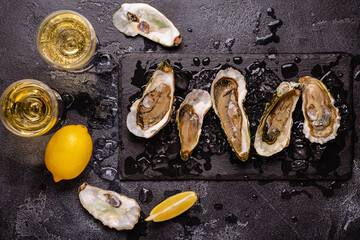 Opened fresh oysters on a plate, served with lemon and ice.