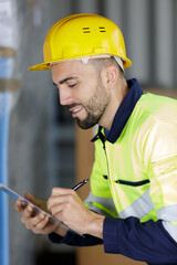 man standing and writing in folder