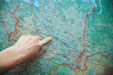 Topographic map in Russian and a finger pointing to a large city.