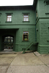 dark green beautiful building with small windows and stairs
