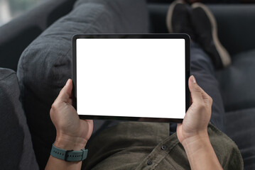 Mockup image of man's hand holding white tablet pc with blank white screen at home