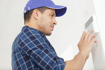 workman setting up the alarm with keyboard