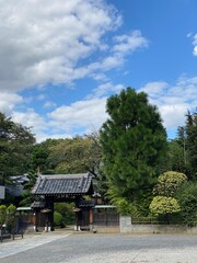 Fototapeta na wymiar Traditoinal gate to a temple with blue sky and clouds, Nezu Tokyo Japan