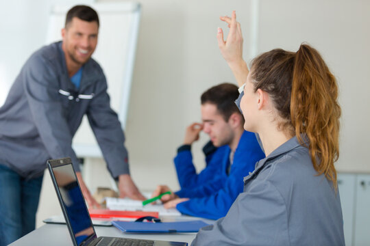 student lifting hand in class