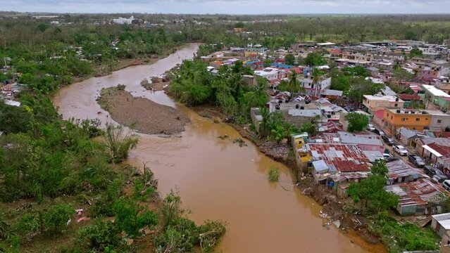 Devastated Town And Muddy Water Of Yuma River After Hurricane Fiona In Los Platanitos Neighborhood in Higuey, Dominican Republic. - aerial