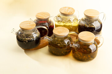 Various teas in teapots on a light background.