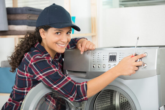 young woman fixing a washing machine