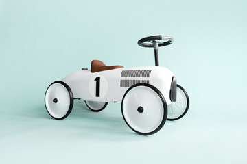 Retro style beige toy car on blue background. Stylish toy for toddler boy. Kid's playing room interior. Copyspace