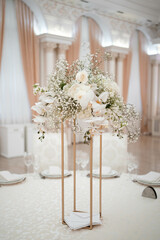 Wedding centerpieces, with metal vase and white fresh flowers arrangements.