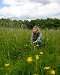 Woman in meadow of flowers and grass enjoying some wellbeing/mental relaxation. 