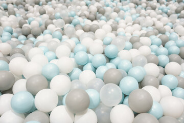 Kid's playing room interior. Colorful white, grey, blue plastic balls background for baby activity. Copyspace