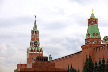 Red square in Moscow with Kremlin towers and Lenin mausoleum on cloudy sky background. Symbol of...