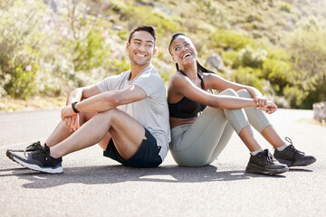 Health, fitness and friends relax after workout in nature, sitting and talking in a road outdoors. Rest, wellness and conversation with diverse man and woman taking a break together after cardio run