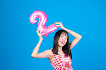 Happy new year and Merry Christmas concept. Beautiful young asian woman with balloons number 2 on blue background.