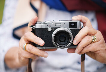 Retro camera, photography and travel with hands of a senior woman taking pictures while traveling,...