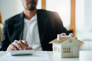 Bank staff at the Mortgage Department are working on paperwork and using a loan interest rate...