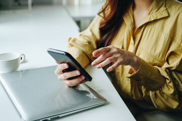 Portrait of a woman using her phone to make video calls or call a friend while taking a break at her desk